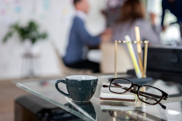 Tasse à café et un œil sur un bureau en verre