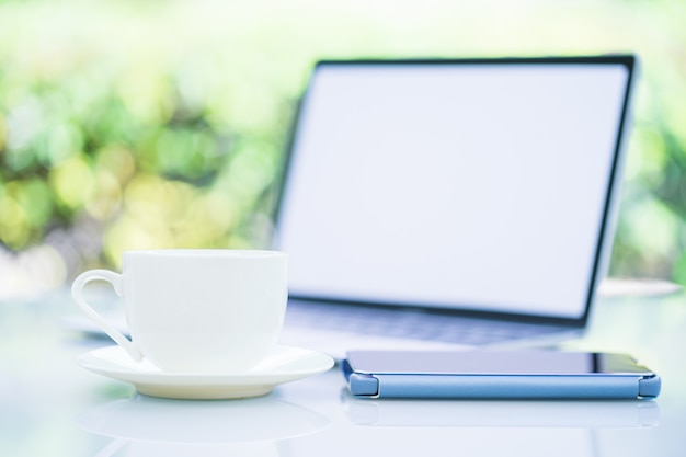 Tasse à café et ordinateur portable au bureau avec smartphone