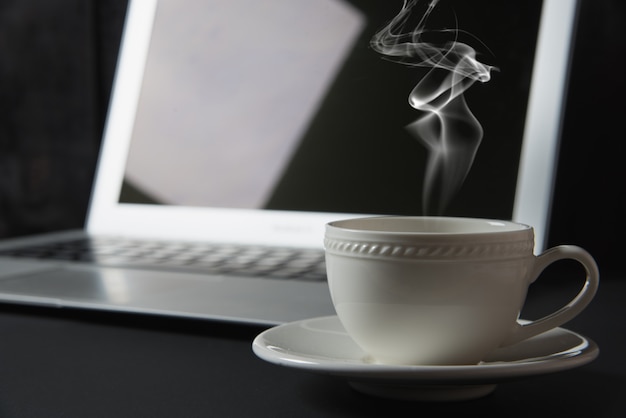 Tasse de café et ordinateur portable sur la table