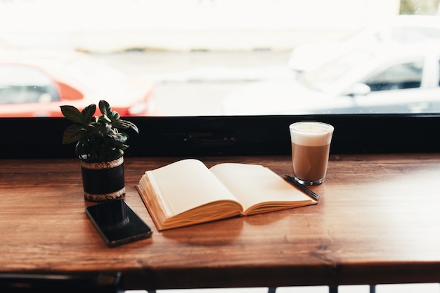 Tasse de café, ordinateur portable, téléphone à table au café