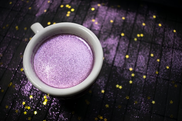 Tasse De Café Avec Des Paillettes Pourpres Sur Fond Sombre