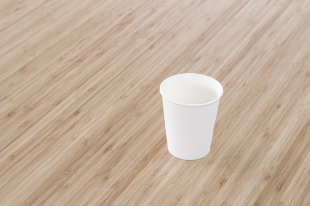 Tasse à café en papier blanc sur table en bois