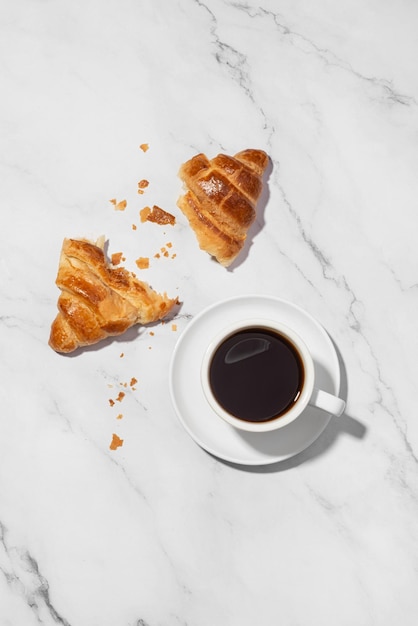 Tasse de café en papier avec croissant sur fond blanc