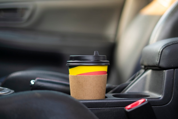 Une tasse de café en papier à emporter à l'intérieur de la voiture