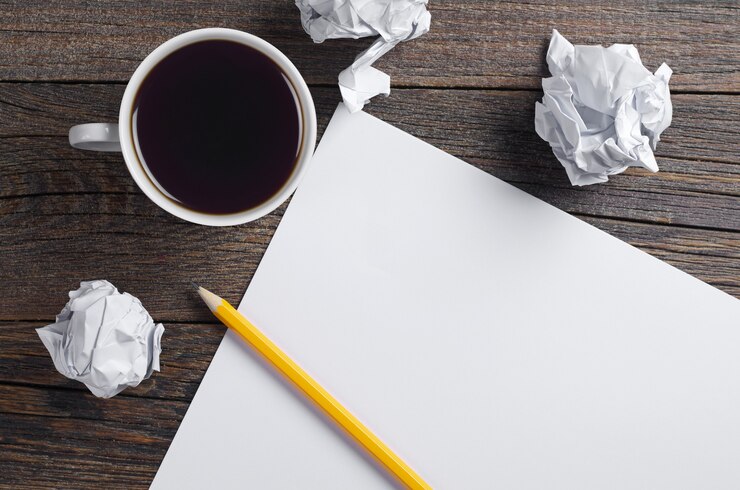 Photo tasse de café, papier froissé et une feuille vierge avec un crayon