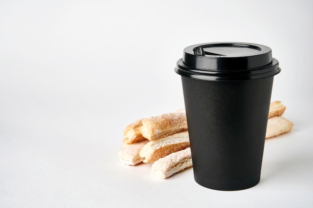 Photo tasse à café en papier et gros plan de bâtonnets de pâte feuilletée