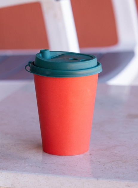 une tasse de café en papier rouge sur la table à café dans le balcon