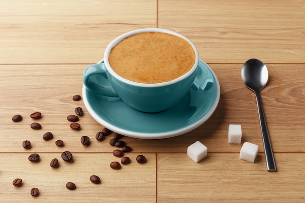 Une tasse de café parfumé en mousse sur une table en bois.