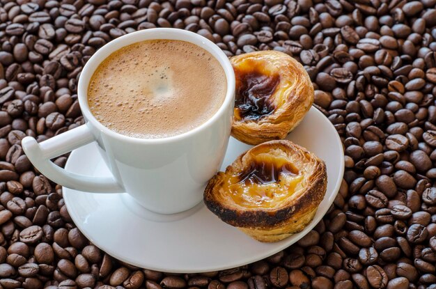 Tasse à café avec pâtisseries Belem sur fond de grains de café