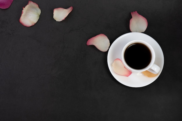 Tasse de café et pétales de rose.