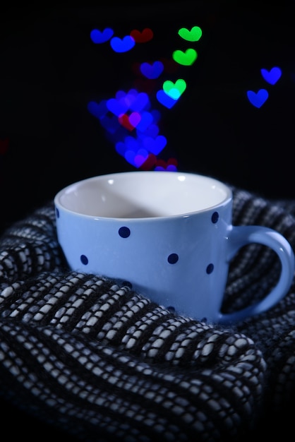 Tasse de café avec plaid sur fond sombre