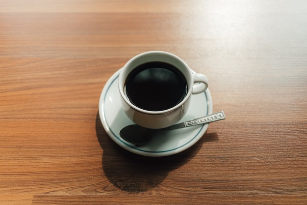 Tasse à café sur le plancher en bois le matin.