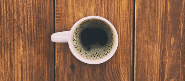 La tasse de café sur le plancher en bois