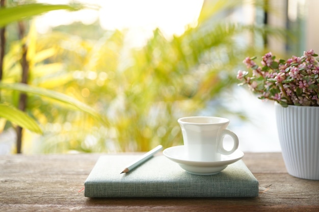 Une tasse de café et une plante Rainbow Bush et un cahier