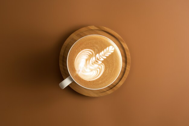 Tasse de café avec une plaque en bois sur fond de couleur marron