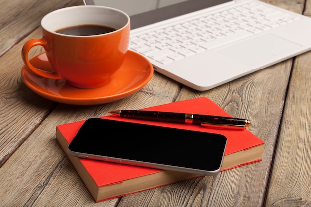 Une tasse de café sur la plaque orange sur la table en bois. Intérieur de bureau