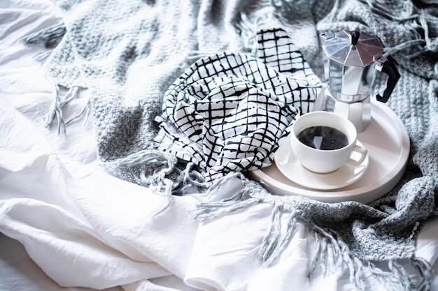 Tasse de café sur plateau en hiver douillet avec couverture en laine