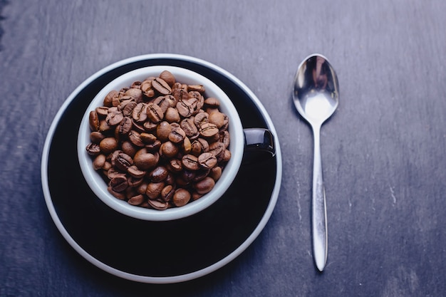 Tasse de café pleine de grains de café