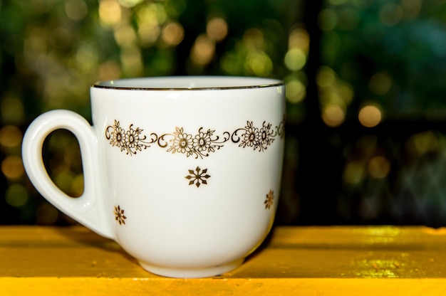 Tasse à café en porcelaine antique sur table jaune