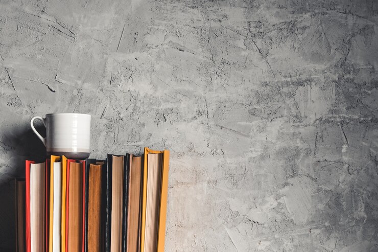Photo une tasse de café près de pile de livres sur fond gris