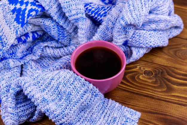 Tasse de café et pull tricoté confortable sur table en bois