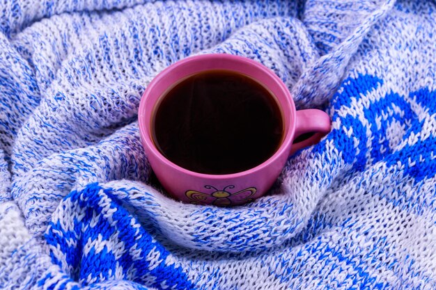 Tasse de café sur un pull tricoté confortable