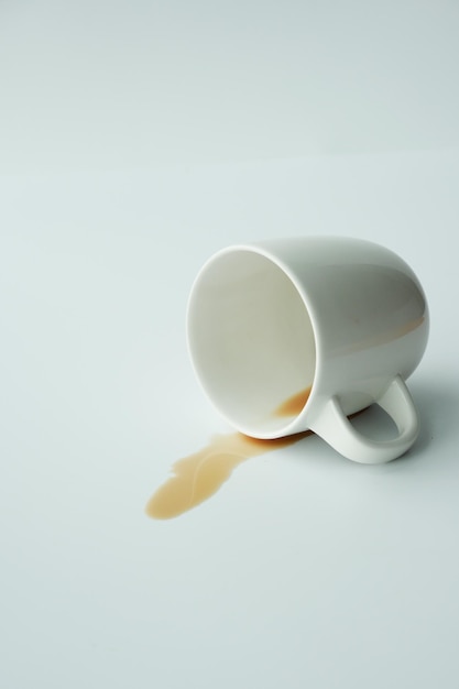 Tasse de café renversée sur fond blanc