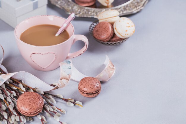 Tasse à café rose avec de doux macarons français pastel