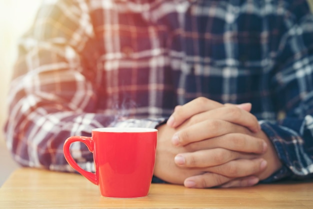 Photo une tasse de café rouge avec un homme