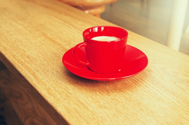 Tasse de café rouge sur une table en bois