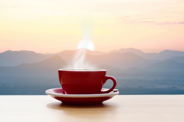 Tasse à café rouge avec vue sur la montagne au soleil du matin