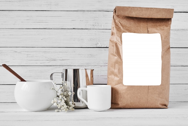 Tasse à café, sac en papier et pichet en acier inoxydable