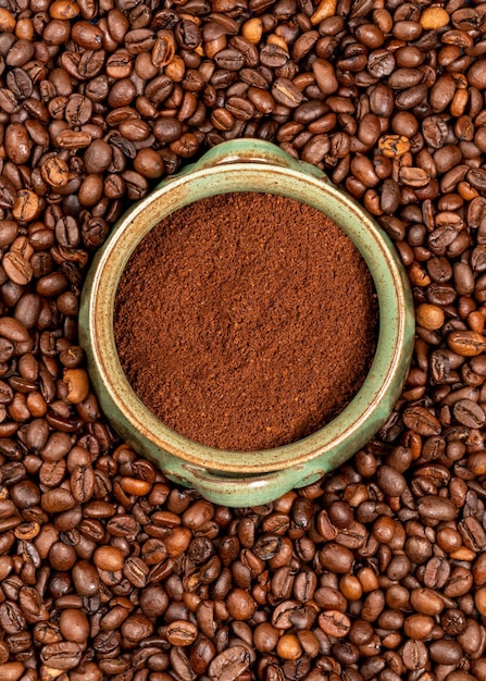 Une tasse de café se trouve dans un tas de grains de café.