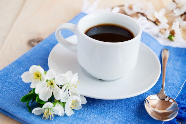 Tasse de café sur une serviette bleue. Fleurs de printemps