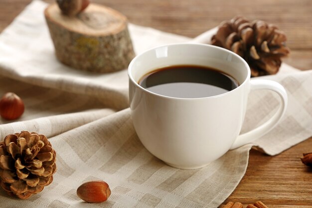 Tasse de café sur une serviette sur fond de bois