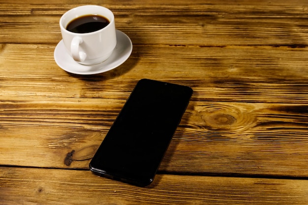 Tasse de café et smartphone sur une table en bois