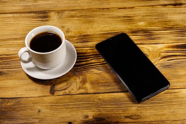 Tasse de café et smartphone sur une table en bois