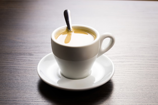 Tasse de café sur une soucoupe avec une cuillère sur la table