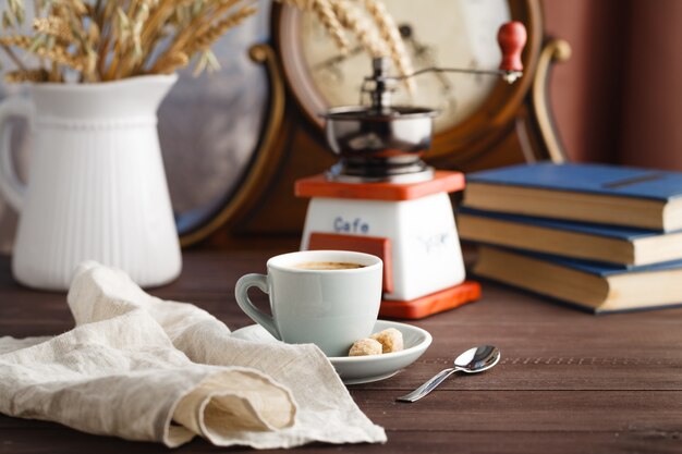 Tasse de café avec soucoupe avec sac avec grains de café sur fond noir