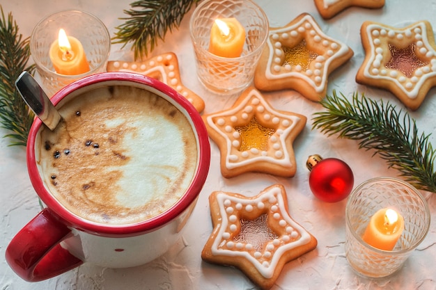 Tasse à café sur une table blanche avec des biscuits au caramel au sucre en forme d'étoile de Noël fait maison