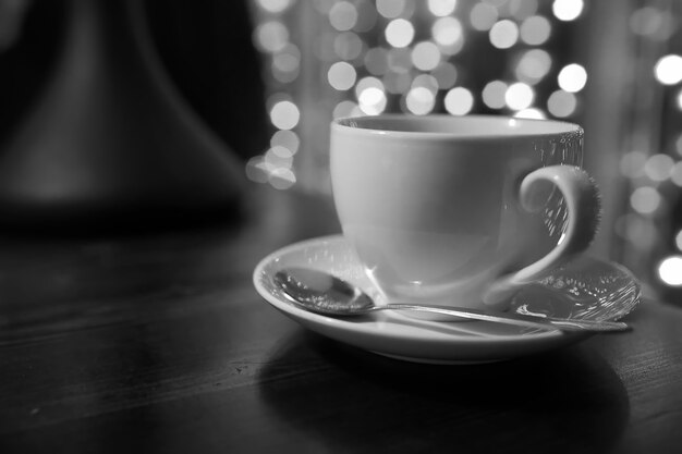 tasse de café sur une table en bois dans le café flou des lumières sur l'arrière-plan