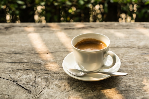 Tasse à café sur la table en bois avec la lumière du soleil