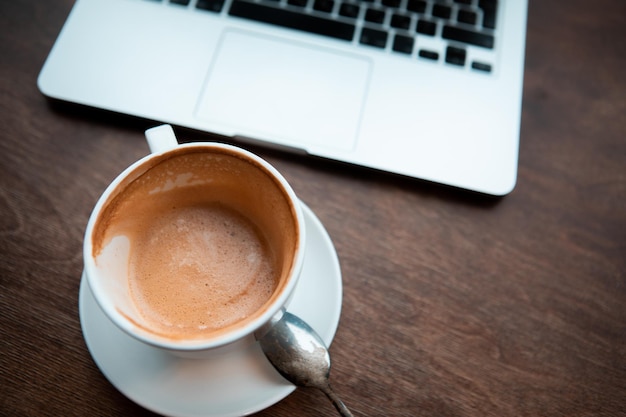 Tasse à café à table en bois avec ordinateur portable