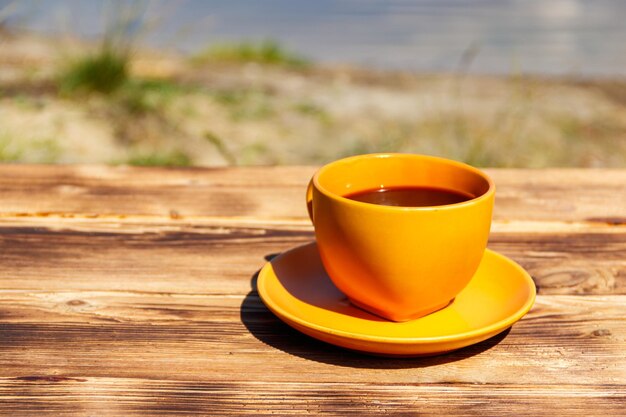 Tasse de café sur la table en bois près de la rivière