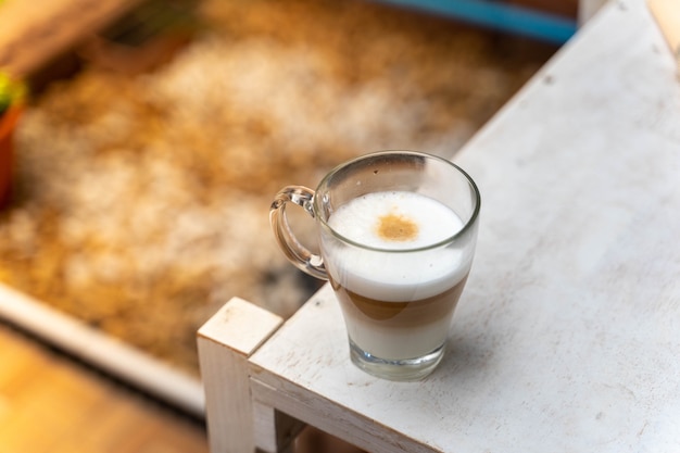 tasse de café sur une table en bois avec temps de pause de travail, concept alimentaire. Verre de café latte chaud avec une belle forme de lait avec copie espace