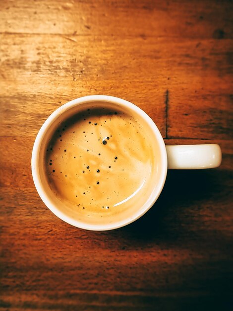 Une tasse de café sur une table en bois.