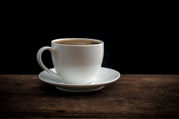 Une tasse de café sur la table sur un fond noir