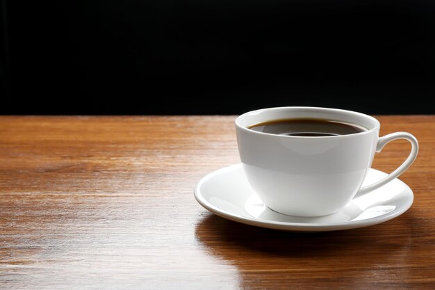 Tasse de café sur la table sur fond sombre