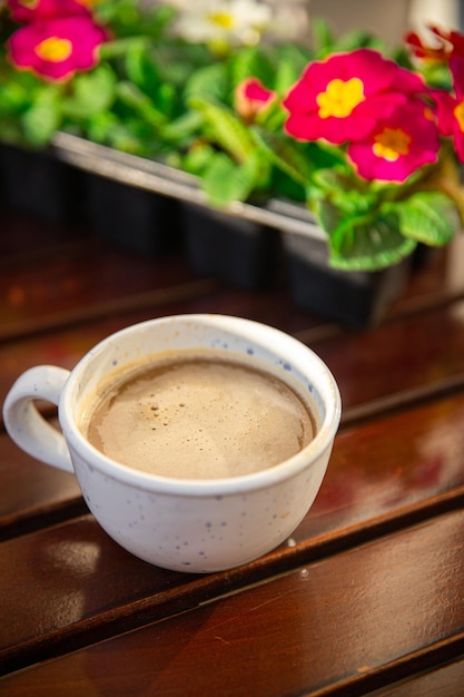 tasse de café sur la table en plein air et fleurs primevère multicolore copie espace arrière-plan alimentaire