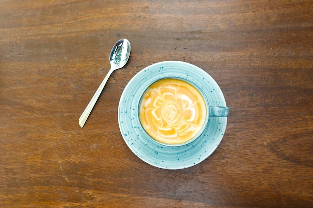 Une tasse de café tardif avec un design en forme de fleur sur le dessus au café